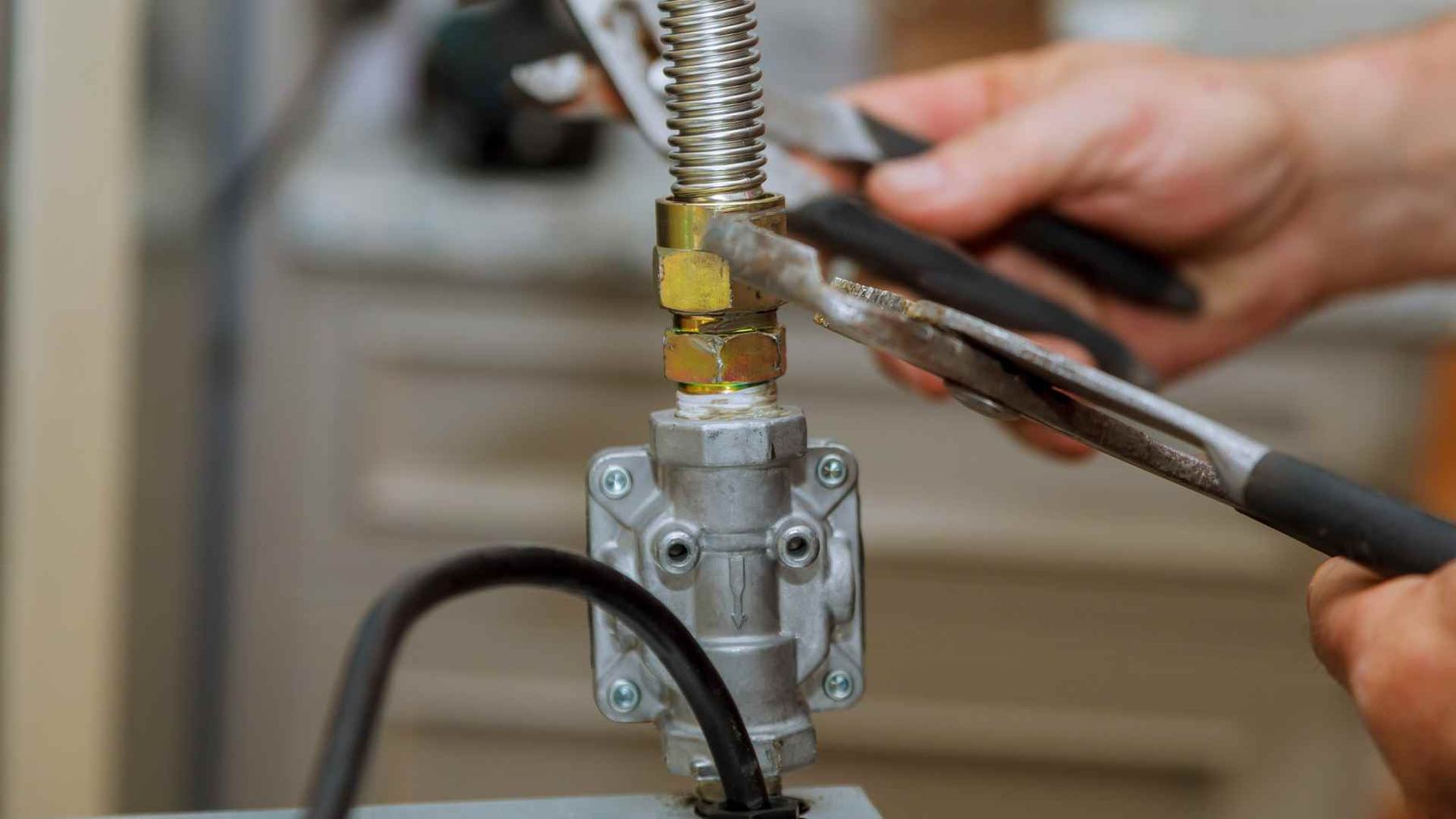 Plumber tightening a gas line fitting with a wrench