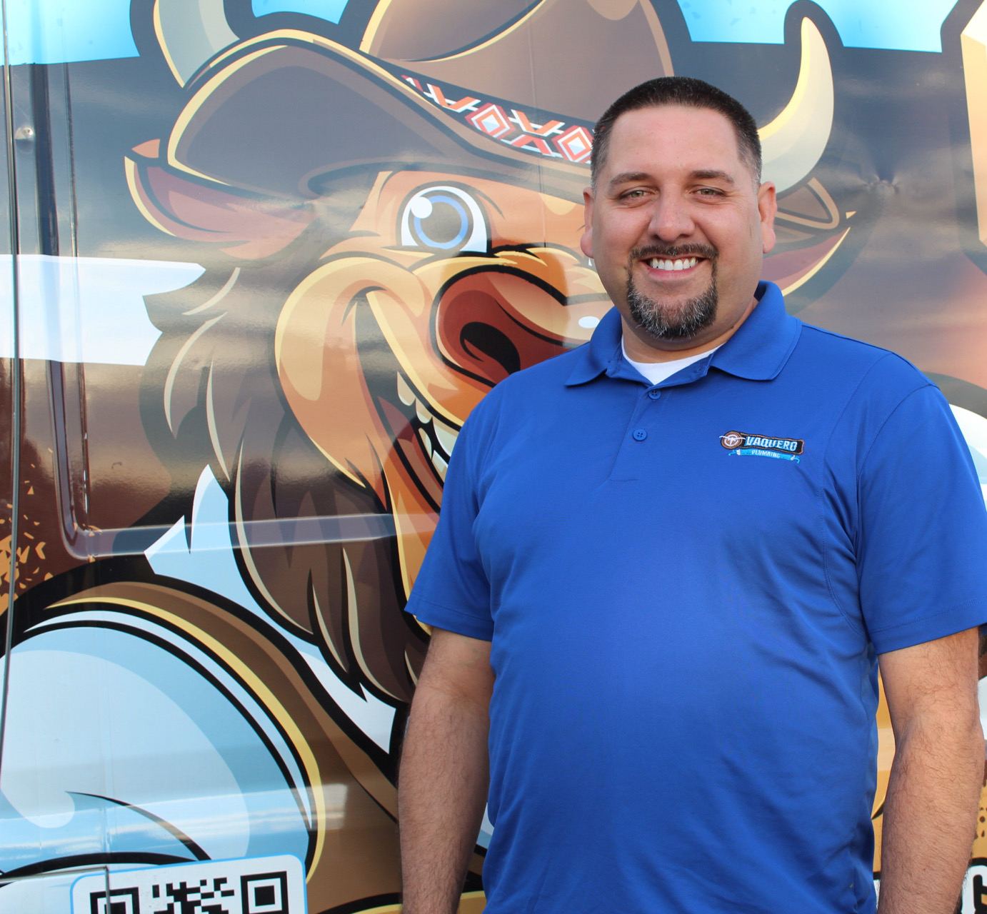 Vaquero Plumbing owner in front of the branded van