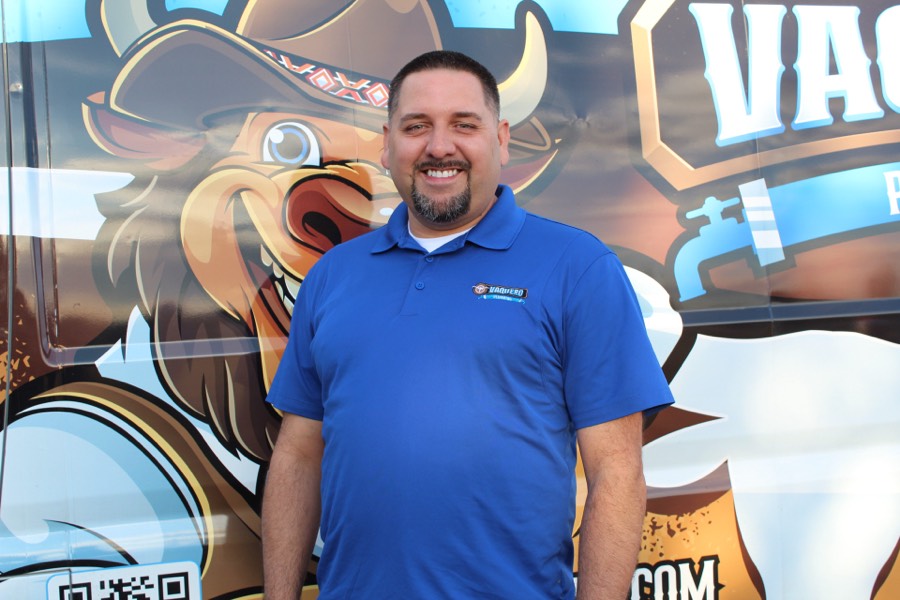 Vaquero Plumbing owner in front of the branded van